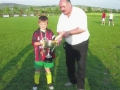Captain of 'AC Milan' Nathan Clancy receives Champions League trophy from George Quinlivan.